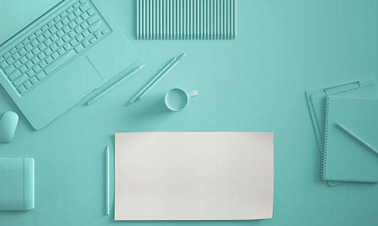 A desk full of writing equipment and a laptop