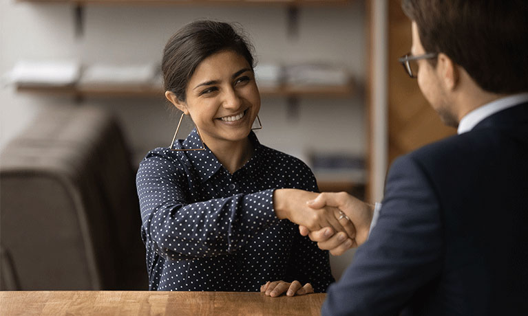woman shaking a mans hand in an office space