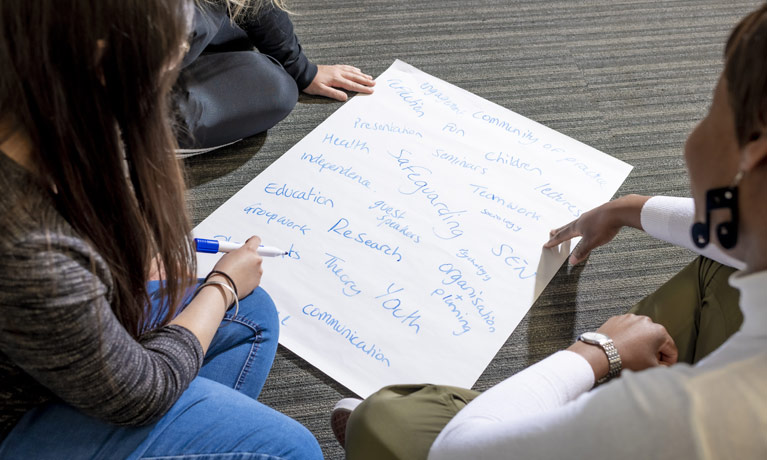 Teahcer and students writing on paper