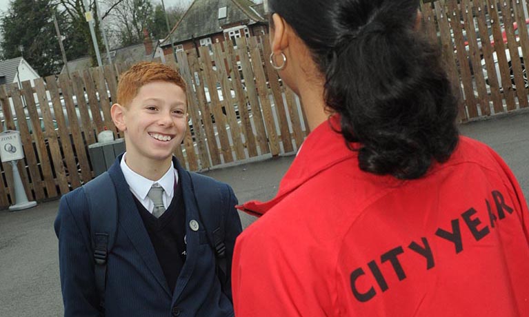 University student volunteer talking to a younger member of the community