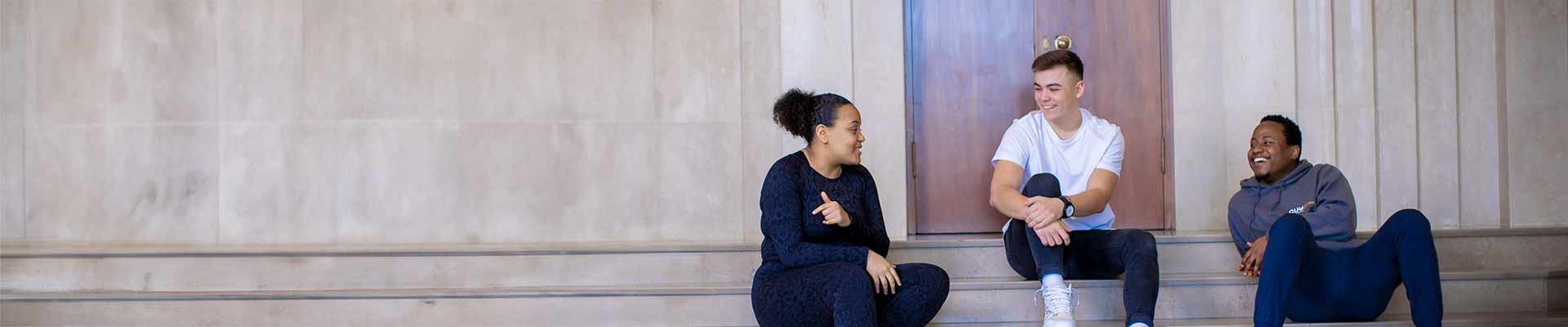 Three students sitting on steps