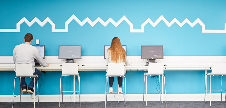 two people sat in the IT Suite, working on computers