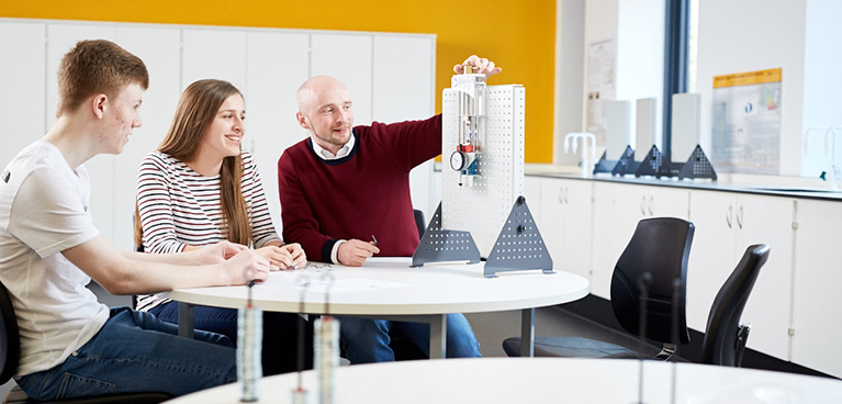 Three people sat in the Engineering lab