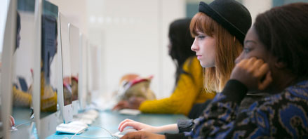 Row of people looking at a computer screen