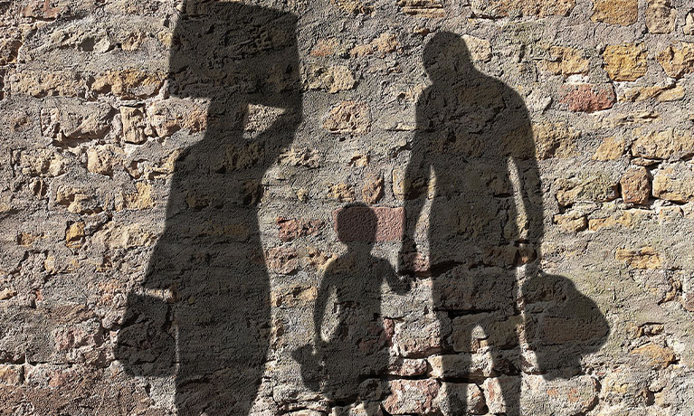 Shadows of refugees on stone wall