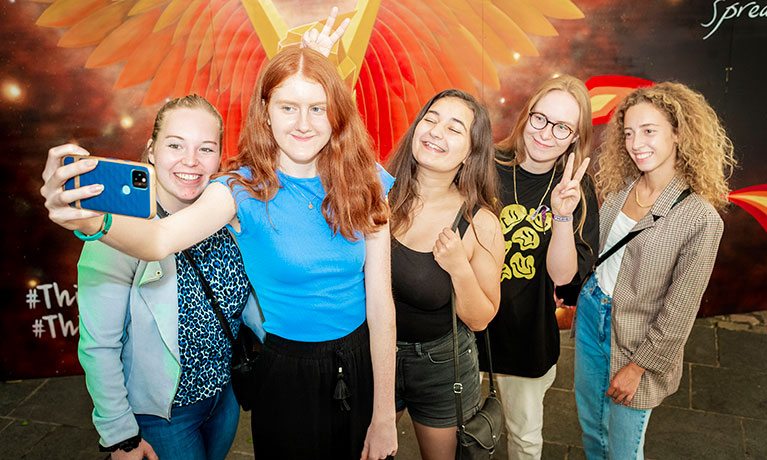 A group of students taking a selfie at an event in halls accommodation.