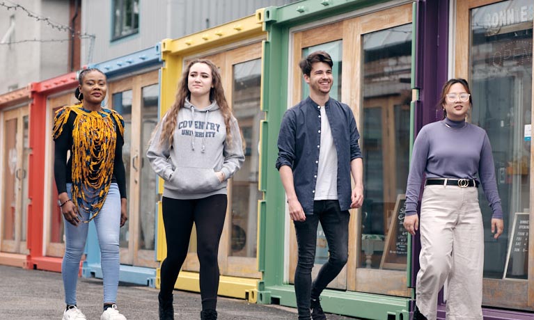 Four students walking outside in Fargo village