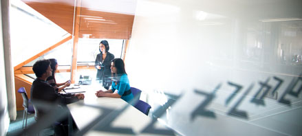 Four people in an office room talking