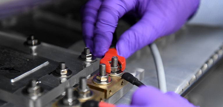 hands wearing rubber gloves, working on some technical equipment
