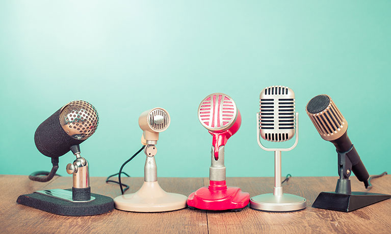 A series of retro microphones sit on a table