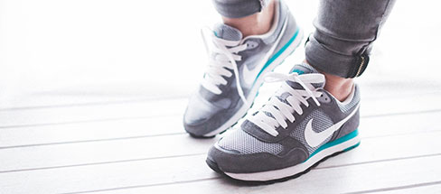 close up of someone wearing grey trainers